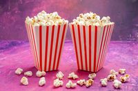 front-view-fresh-popcorn-light-pink-table-color-cinema-movie